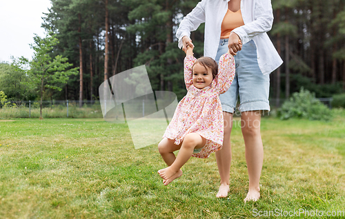 Image of happy mother playing with baby daughter outdoors