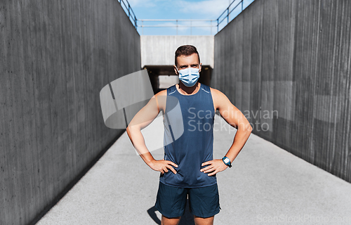 Image of young man in medical mask doing sports outdoors