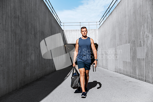 Image of sportsman with bag and bottle outdoors