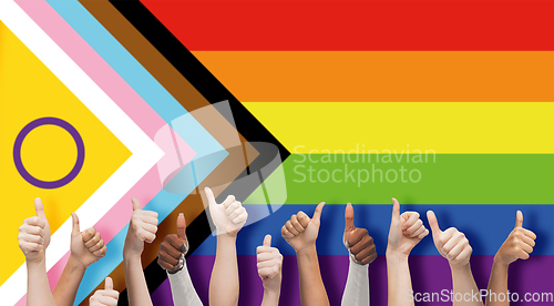 Image of hands showing thumbs up over progress pride flag