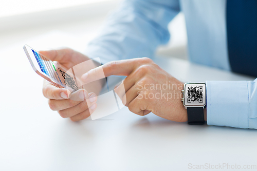 Image of hands with virtual immunity passport on smartphone