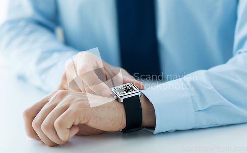 Image of man's hands with qr code on smart watch
