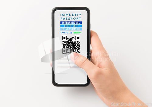 Image of hand holding phone with certificate of vaccination