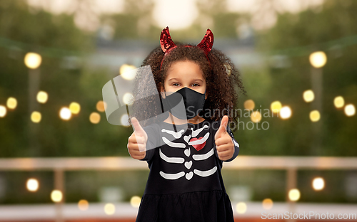 Image of girl in black mask showing thumbs up on halloween