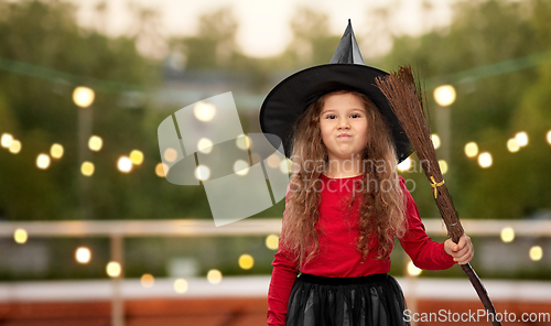 Image of girl in black witch hat with broom on halloween