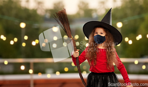 Image of girl in black mask and halloween costume of witch