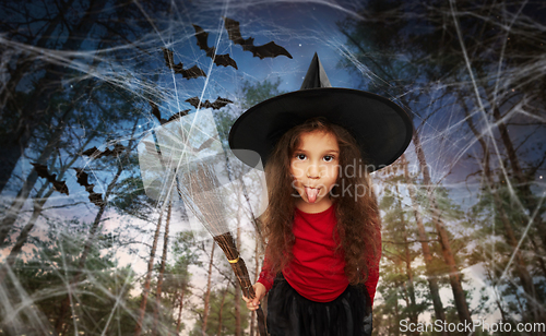 Image of girl in black witch hat with broom on halloween