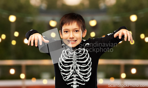 Image of boy in halloween costume of skeleton frightening