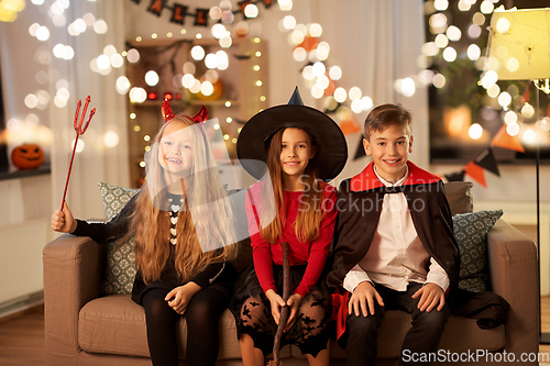 Image of kids in halloween costumes at home at night