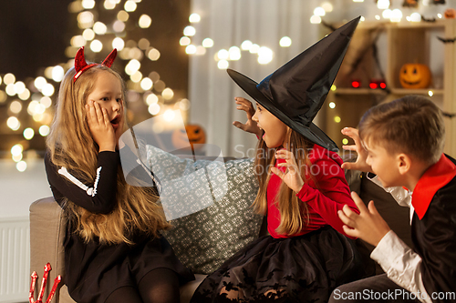 Image of kids in halloween costumes playing at home