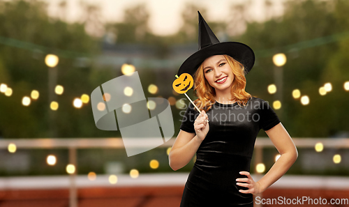 Image of woman in halloween costume of witch with pumpkin