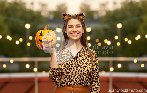 Image of woman in halloween costume of leopard with pumpkin