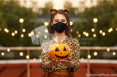 Image of woman in halloween costume and mask with pumpkin