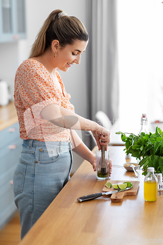 Image of woman making cocktail drinks at home kitchen