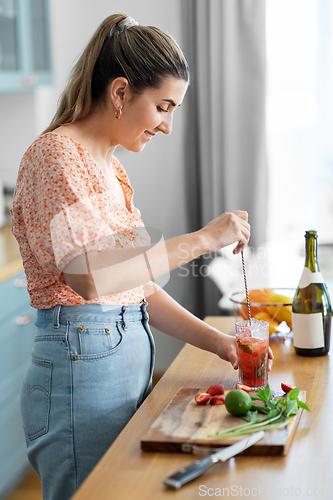 Image of woman making cocktail drinks at home kitchen