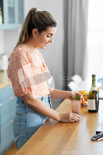 Image of woman making cocktail drinks at home kitchen