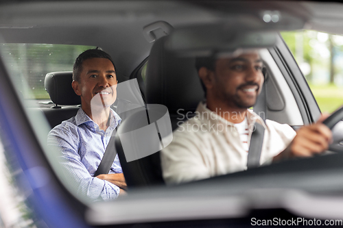 Image of indian male driver driving car with passenger