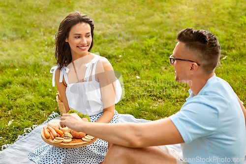 Image of happy couple having picnic at summer park