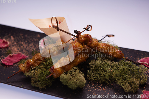 Image of deep fried chicken tendons and sauce on white dish with wooden background