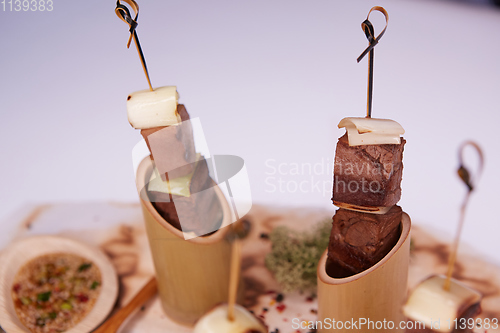 Image of Grilled pork meat with sauce inserted with bamboo sticks. Shallow dof