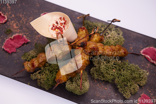 Image of deep fried chicken tendons and sauce on white dish with wooden background