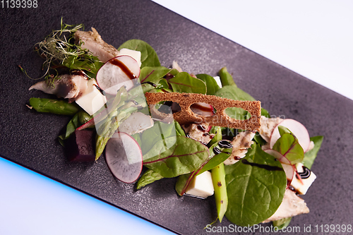 Image of Green salad with radish and croutons. Shallow dof
