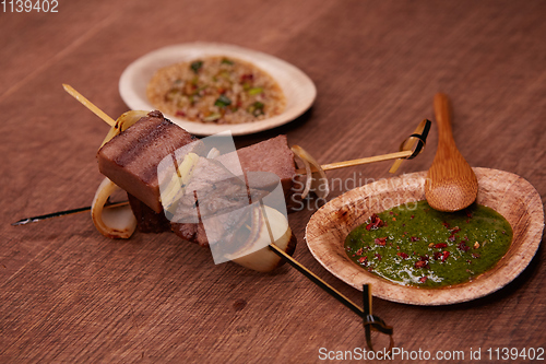 Image of Grilled pork meat with sauce inserted with bamboo sticks. Shallow dof