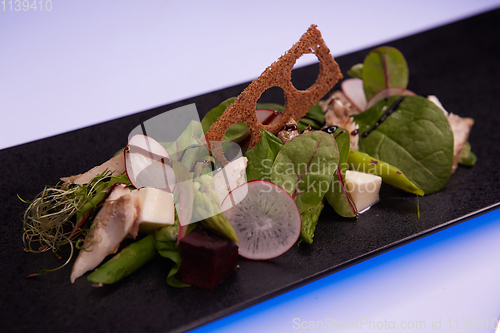 Image of Green salad with radish and croutons. Shallow dof