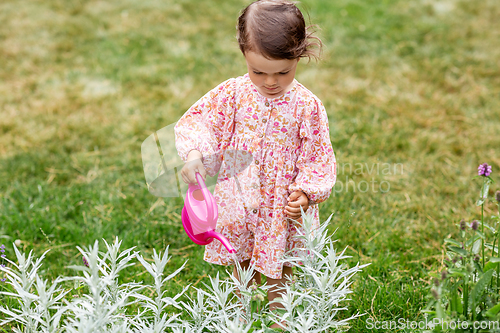 Image of happy baby girl with watering can in summer garden