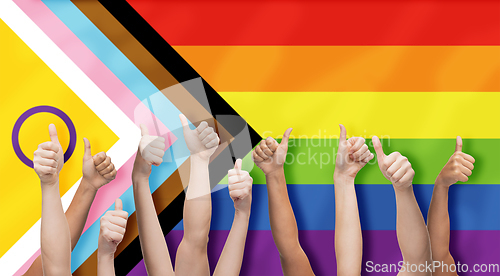 Image of hands showing thumbs up over progress pride flag