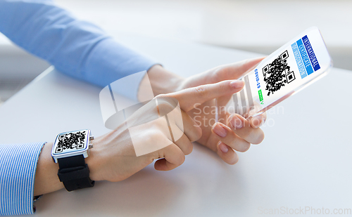 Image of hands with virtual immunity passport on smartphone