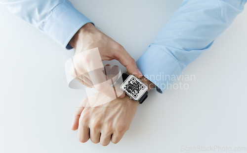 Image of man's hands with qr code on smart watch