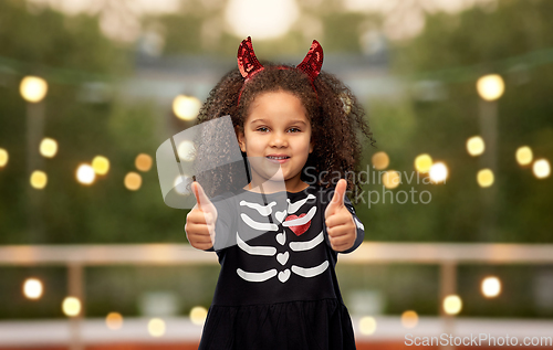 Image of girl in black dress and devil's horns on halloween