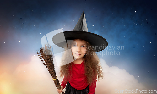 Image of girl in witch hat with broom on halloween at night