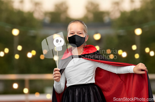 Image of girl in mask and costume of dracula on halloween