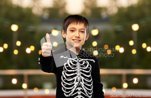 Image of boy in halloween skeleton costume shows thumbs up