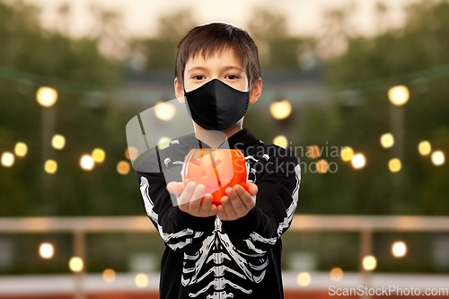 Image of boy in mask and halloween costume with pumpkin