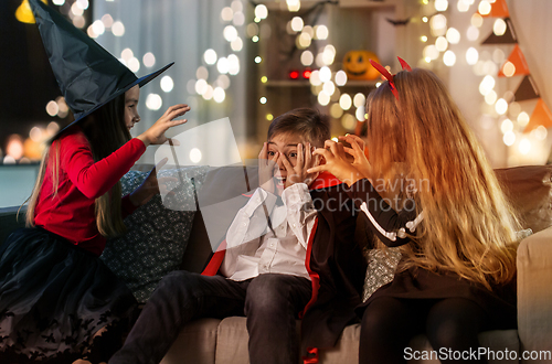 Image of kids in halloween costumes playing at home