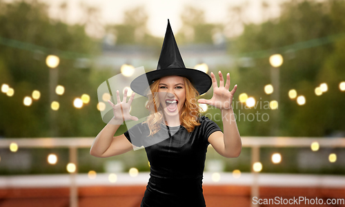 Image of scary woman in black halloween costume of witch