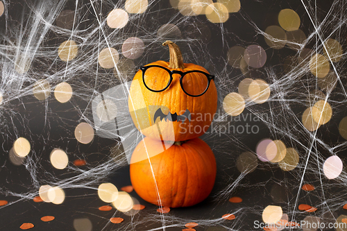 Image of halloween pumpkins with glasses, bat and spiderweb