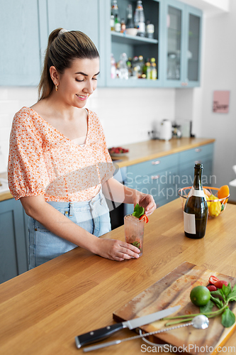 Image of woman making cocktail drinks at home kitchen