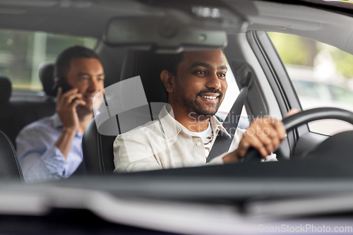 Image of indian male driver driving car with passenger