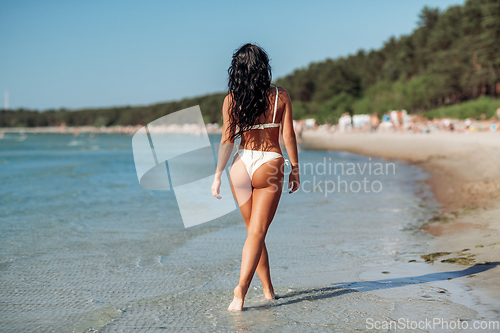 Image of young woman in bikini swimsuit on beach