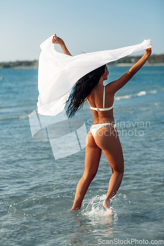 Image of woman in bikini swimsuit with cover-up on beach