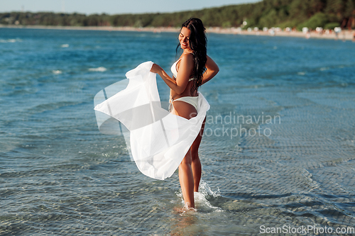 Image of woman in bikini swimsuit with cover-up on beach