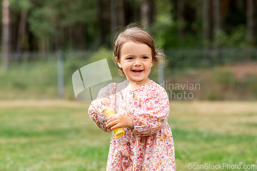 Image of happy baby girl with soap bubble blower in summer