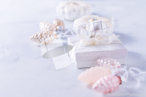 Image of Christmas gift with ornaments in white.