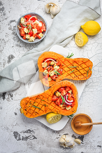 Image of Halved roasted butternut squash with spicy vegetable filling and feta cheese