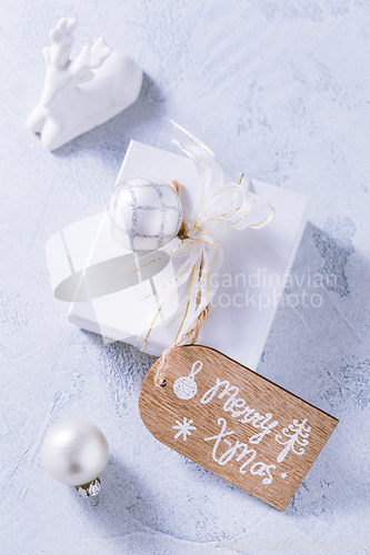 Image of Christmas gift with ornaments in white.