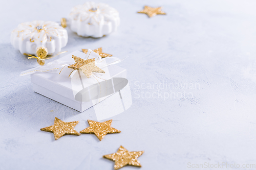 Image of Christmas gift with ornaments in white. 